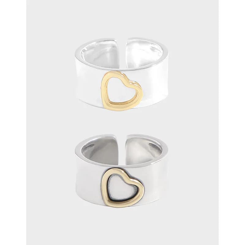 Wide matte silver ring with gold heart outline accent shown from two angles.