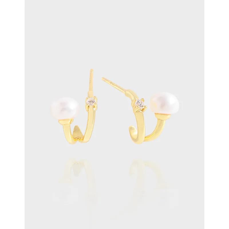 Polished sterling silver curved hoop earrings with a single pearl and small crystal accent.