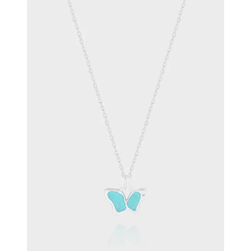 Sterling silver necklace with turquoise butterfly pendant centered on a light background.