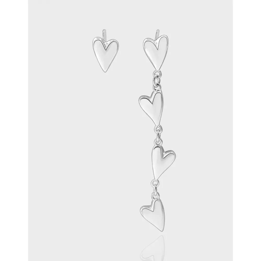 Polished sterling silver triple heart earrings with a three-heart chain dangle on a light grey background.