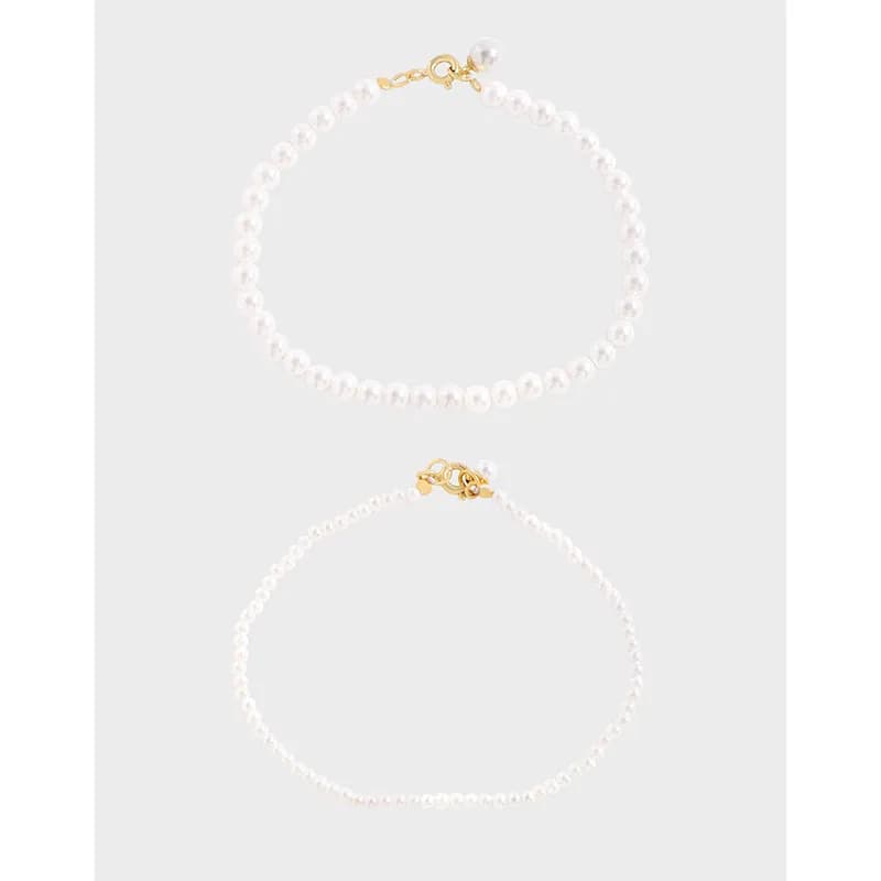 Polished sterling silver bracelet with white freshwater pearl beads and a small gold-tone clasp