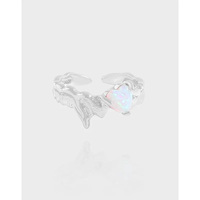 Polished silver ring with a heart-shaped opal centerpiece and organic leaf-like band.