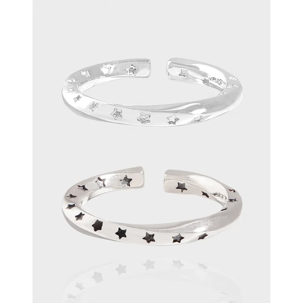 Polished sterling silver open ring with star motifs along the band.