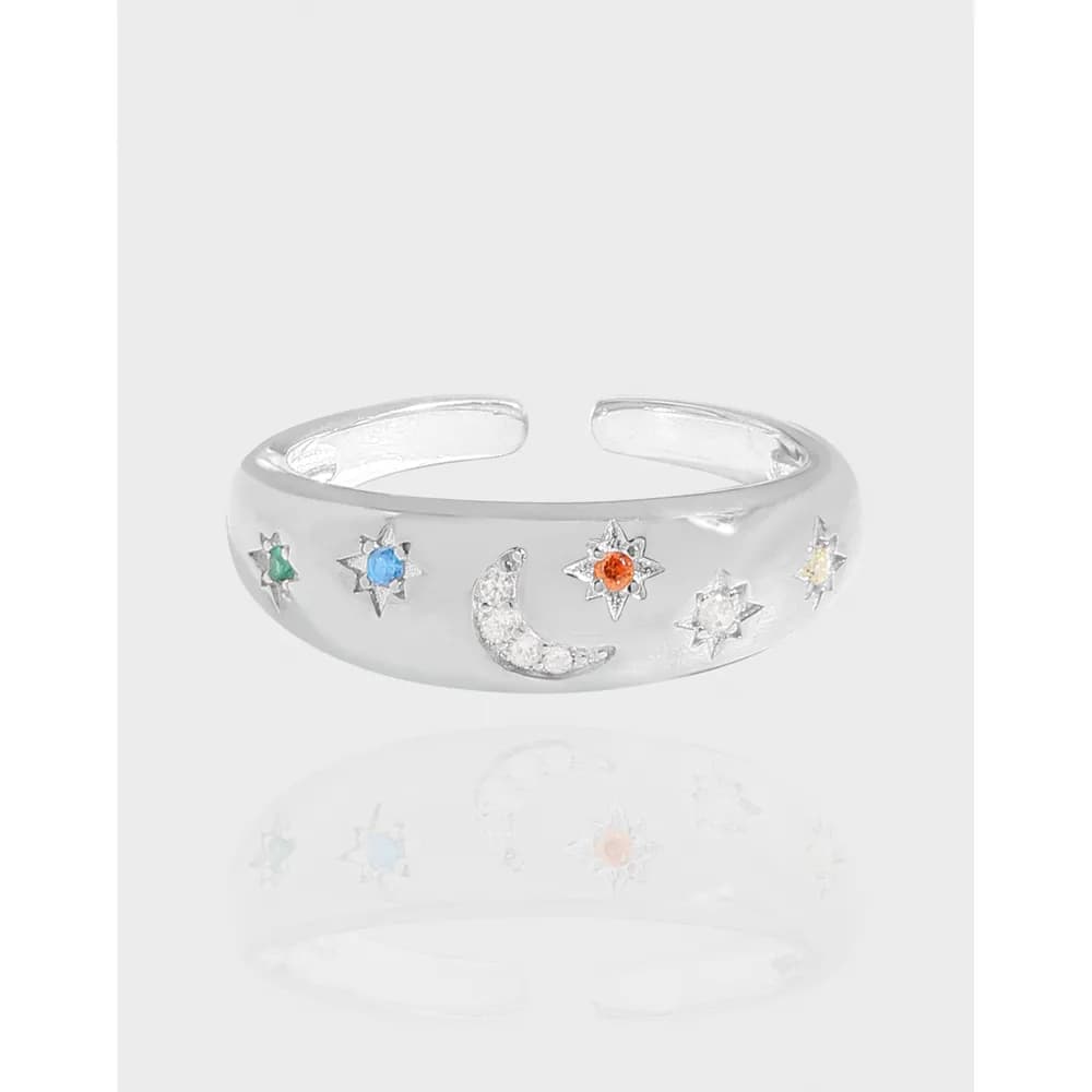 Polished sterling silver ring with a crescent moon and star accents along the band.