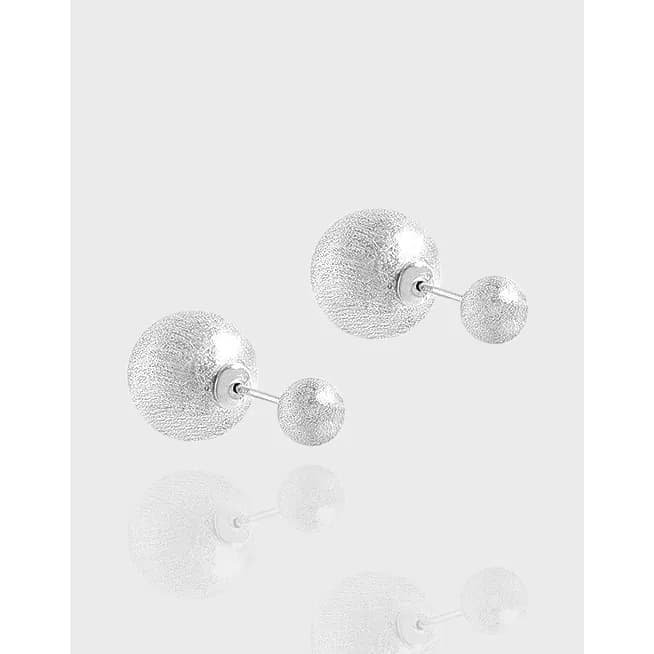 Pair of sterling silver double-ball textured stud earrings on a light background.