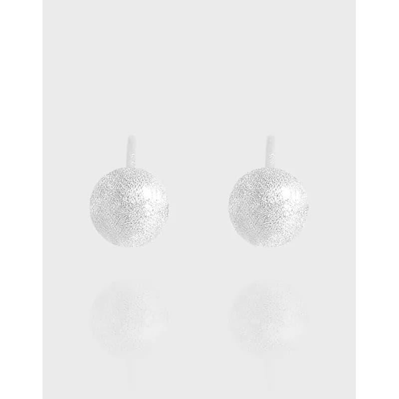 Two textured silver sphere earrings shown on a pale background.