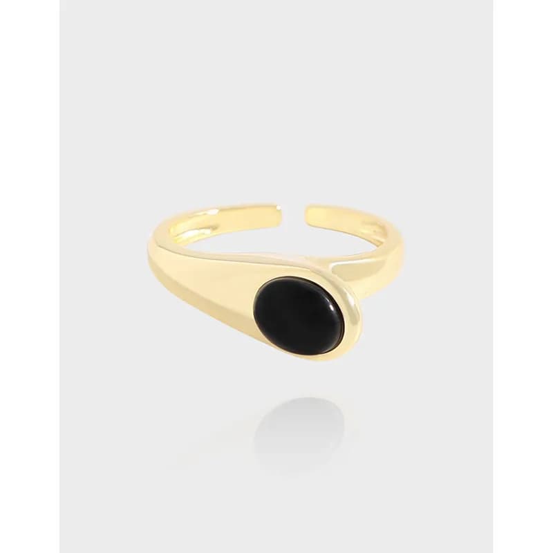 Polished sterling silver ring with a black round cabochon bezel setting on a light background.