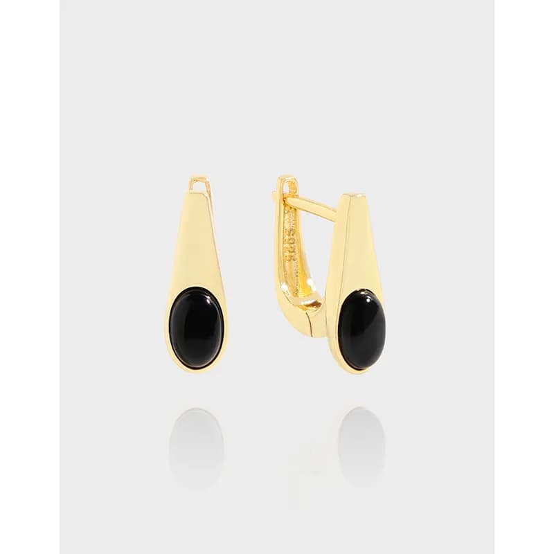 Gold-tone teardrop earrings with black oval cabochon stones in a hinged back setting.