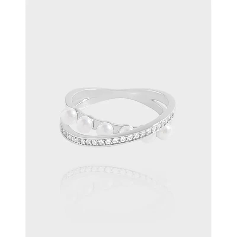 Polished sterling silver ring with pavé crystals and pearl accents on an open wrap band.