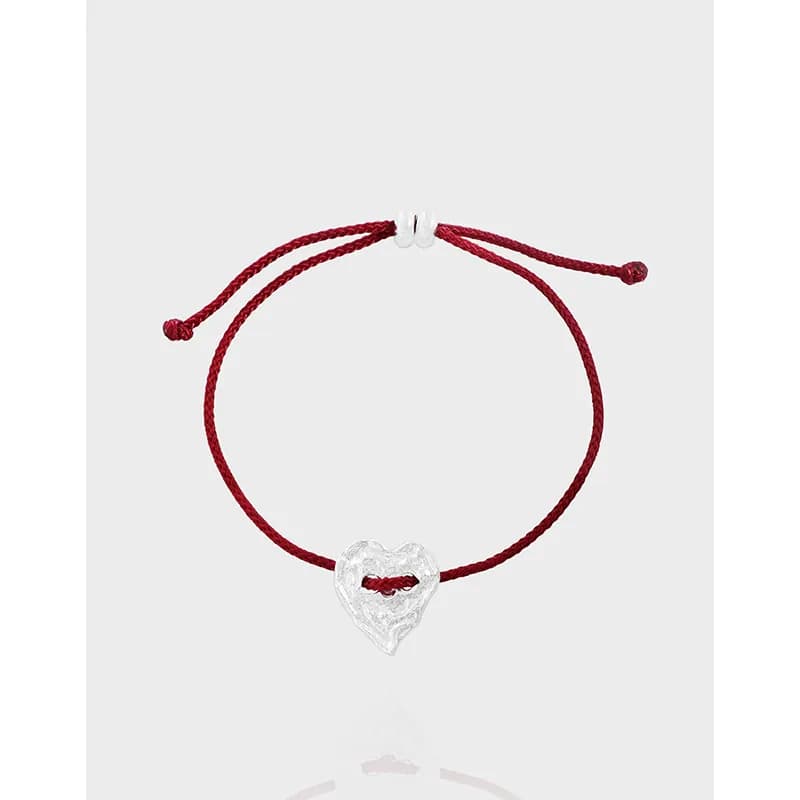 Red adjustable cord bracelet with a textured silver heart charm on the front.