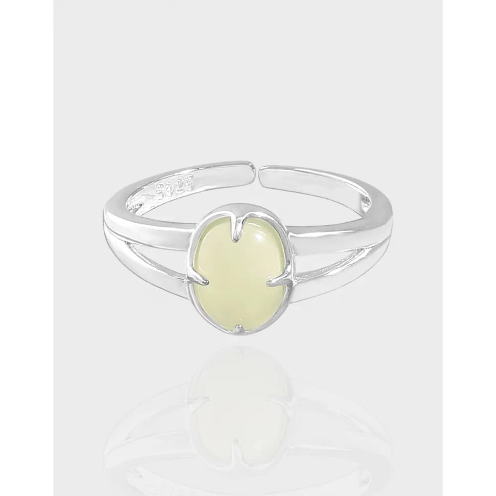 Polished sterling silver ring with a pale yellow heart-shaped cabochon centerpiece on a light background.