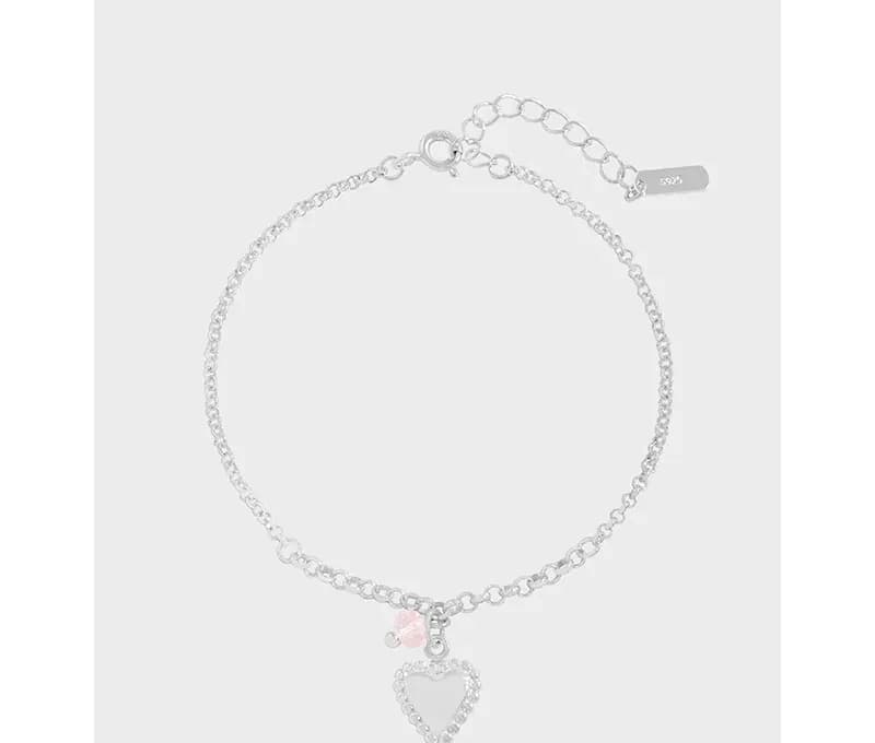 Delicate sterling silver bracelet with a pavé heart charm and pink bead pendant on a thin chain.