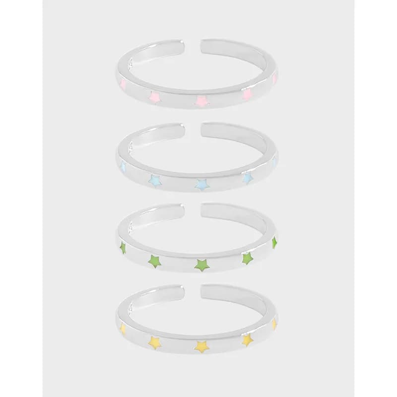 Four sterling silver open-band rings with pastel enamel stars in pink, blue, green, and yellow