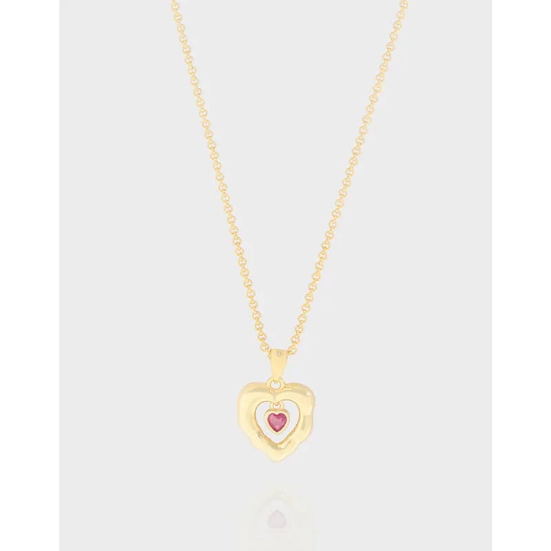 Delicate sterling silver necklace with a heart pendant featuring a smaller pink heart inside