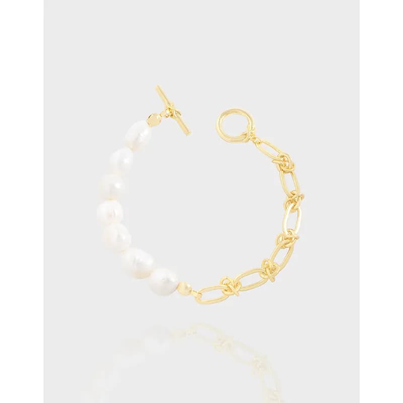 Two-tone bracelet with white pearls on one side and gold chain links on the other, shown against a light background.