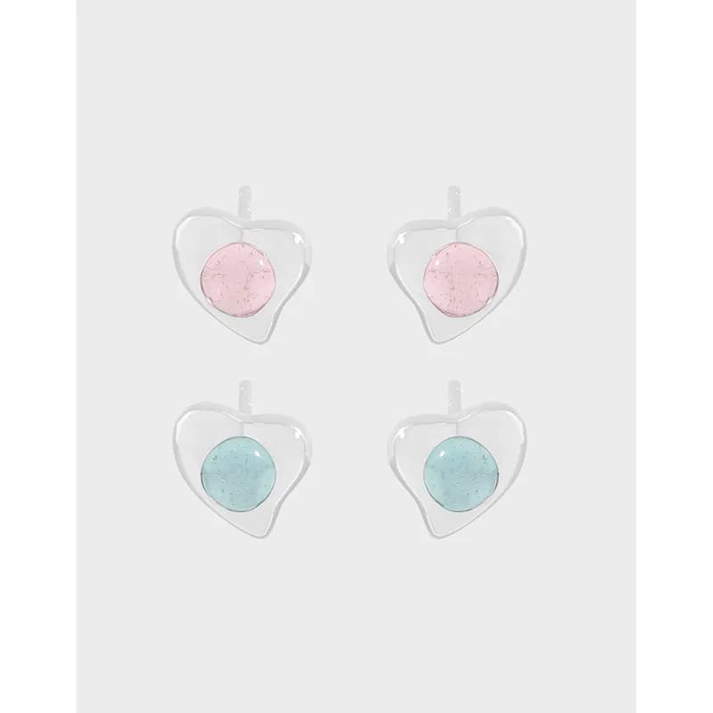 Four heart-shaped sterling silver earrings with pink and blue enamel centers on a light background.