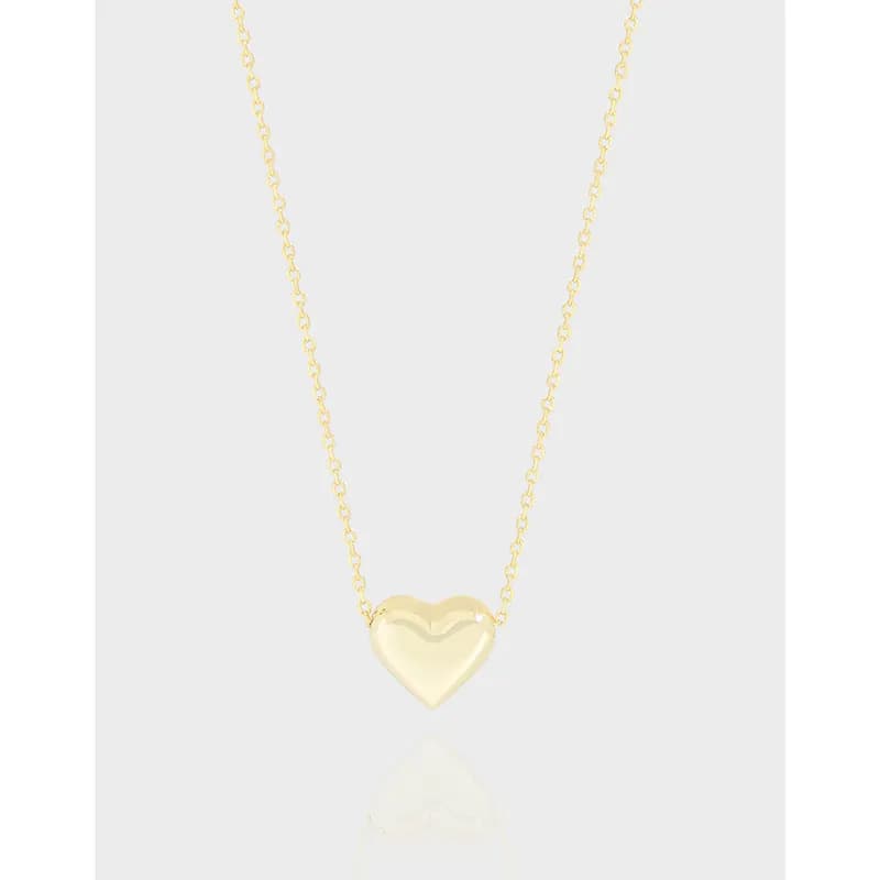 Delicate heart pendant centered on a fine chain against a light background.