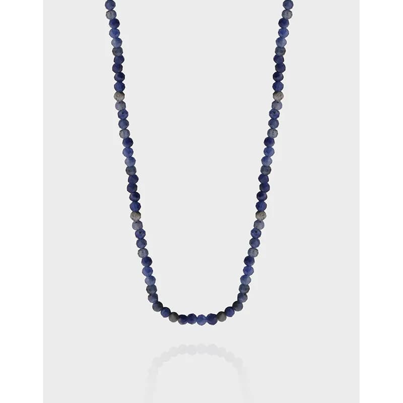 Polished sterling silver bead necklace with deep blue round beads draped into a gentle U-shape.
