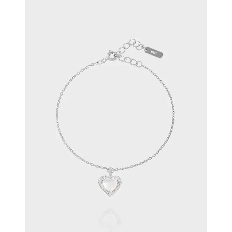 Delicate sterling silver bracelet with a hollow pavé-heart charm on a thin chain.