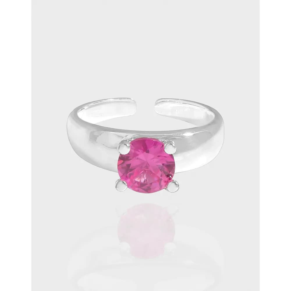 Polished sterling silver ring with a pink round gemstone in four prongs on a light gray background.
