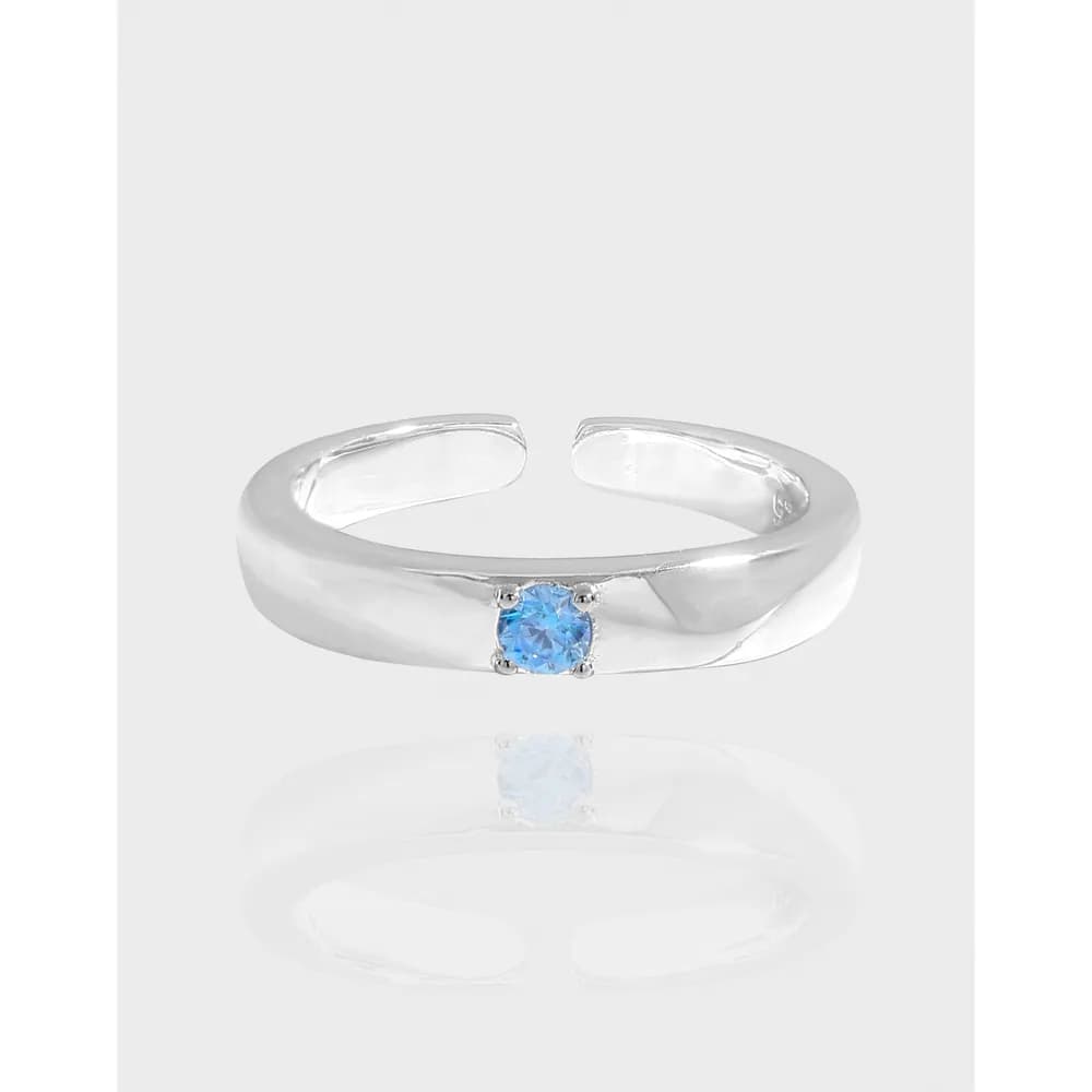 Polished sterling silver ring with a blue round gemstone centered on a simple band.