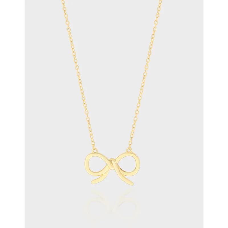 Polished sterling silver infinity bow pendant hanging on a thin chain against a light background.
