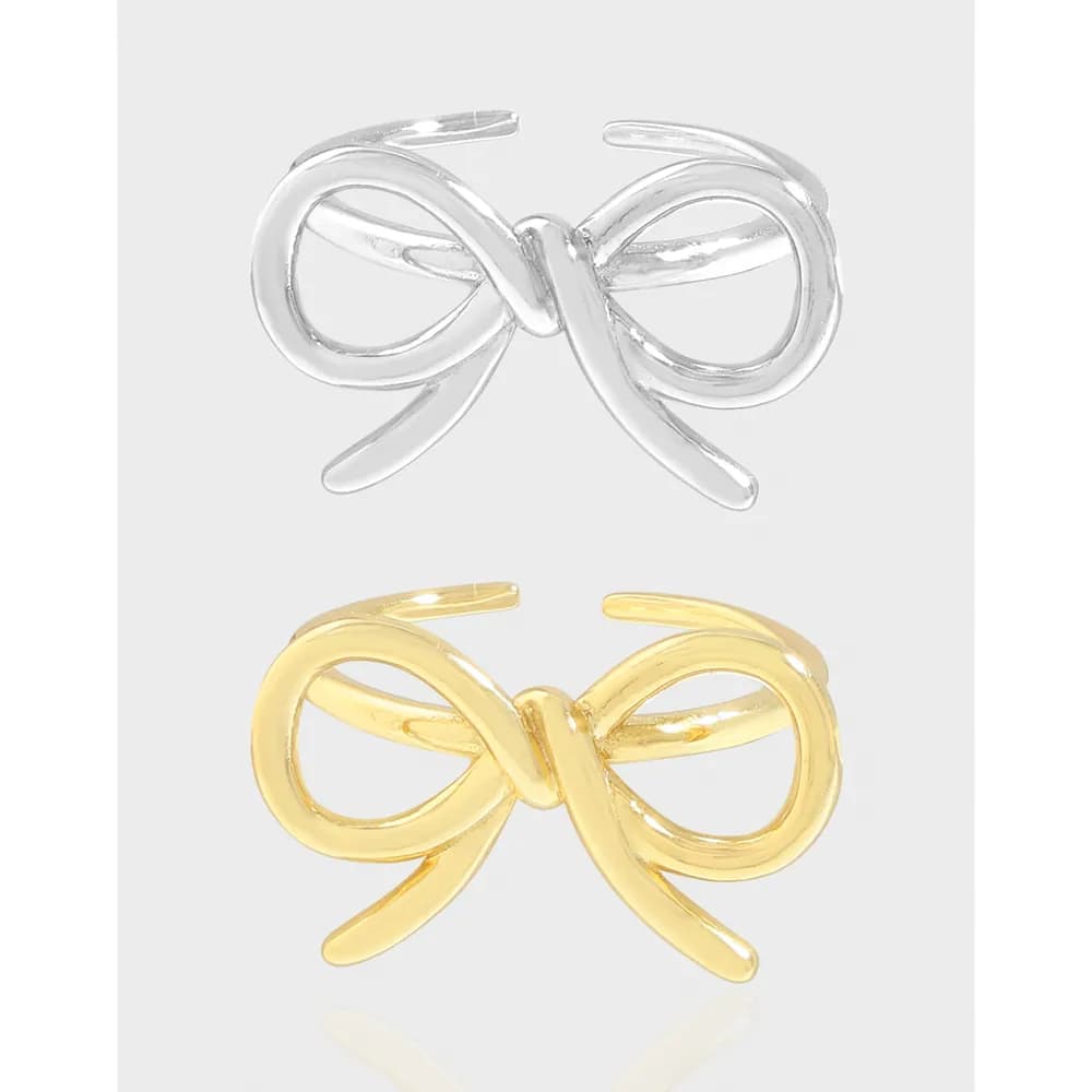 Two bow knot rings, one silver and one gold, displayed on a light gray background.