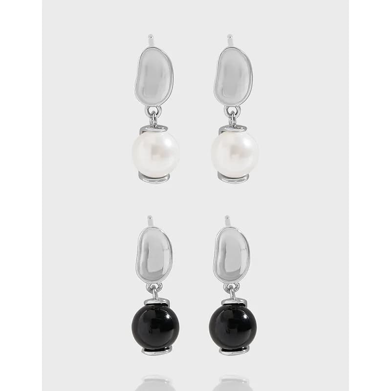 Sterling silver drop earrings with an oval top and dangling pearl-like spheres in white and black colorways.