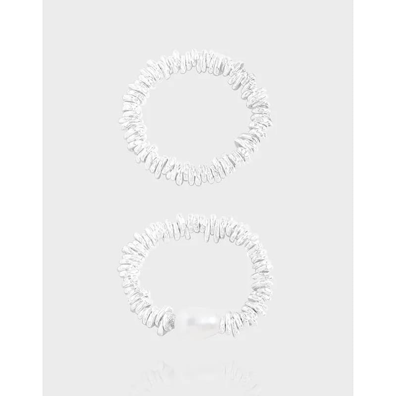 Two sterling silver hammered disc rings, one with a pearl accent, displayed against a pale background.