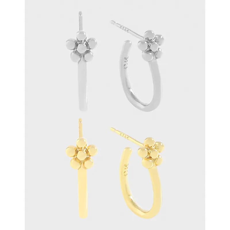 Polished hoop earrings with a five-petal flower cluster on top in silver and gold finishes.