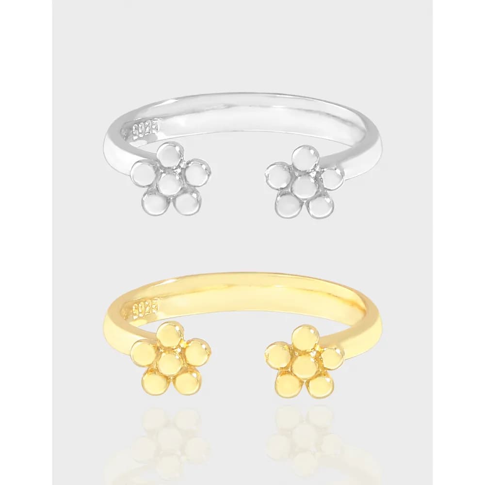 Polished sterling silver ring with two five-petal flower caps at each end on a slim open band.