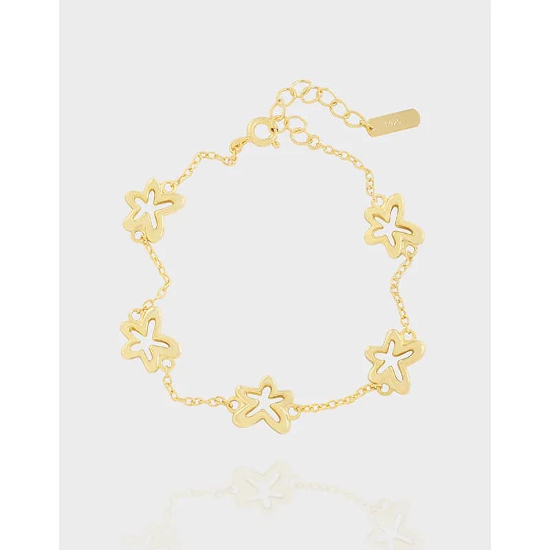 Gold-tone flower-link bracelet with five open-petal charms on a delicate chain