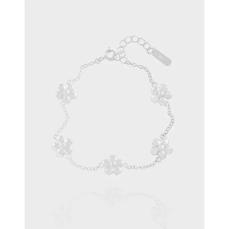 Polished sterling silver bracelet with five-petal flower charms along a delicate chain.