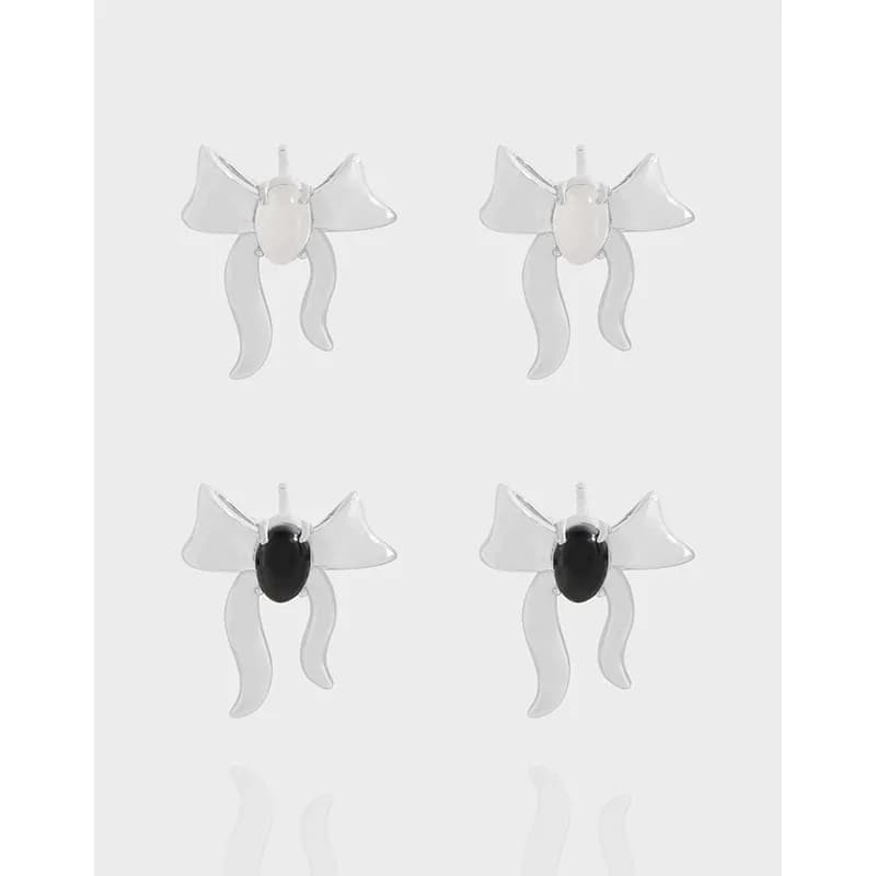 Polished sterling silver bow earrings with ribbon tails and oval centers, shown as a pair for pierced ears.