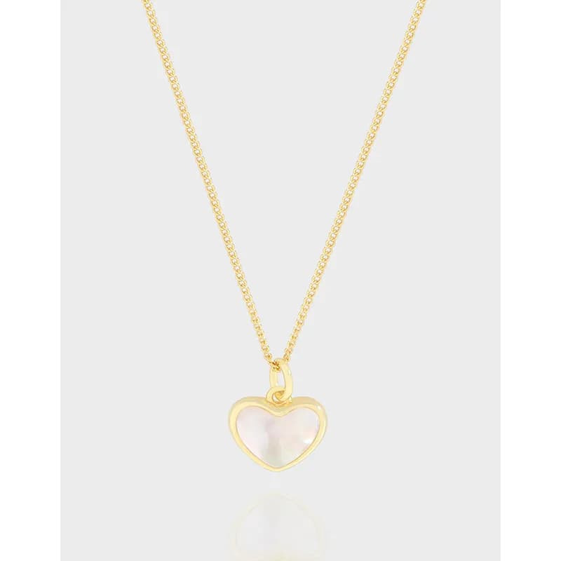 Polished sterling silver necklace with a gold-tone heart pendant and iridescent center on a light background.