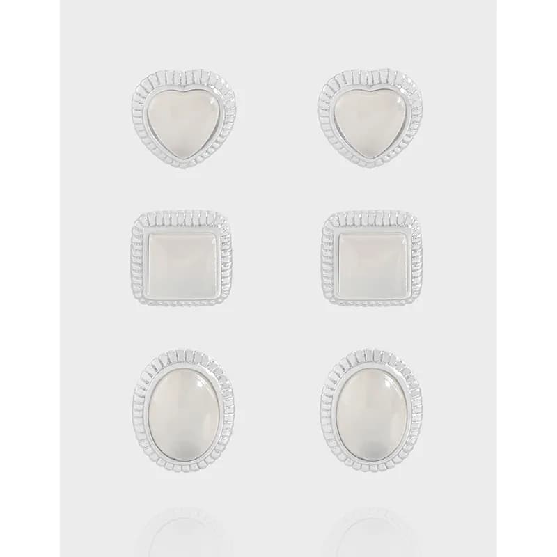 Six pairs of sterling silver stud earrings with mother-of-pearl centers in heart, square, and oval shapes