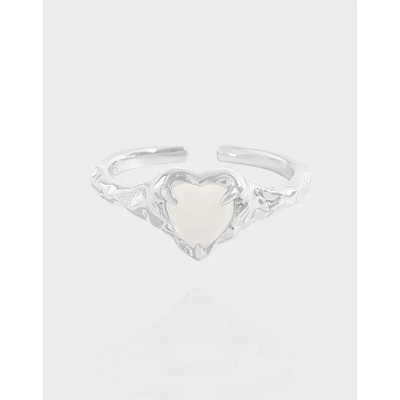 Polished sterling silver ring with a heart-shaped ivory centerpiece and ornamental filigree band