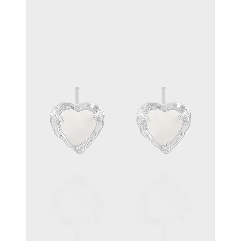 Polished sterling silver heart-frame stud earrings with white heart centers on a light background.