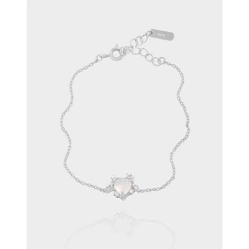 Delicate sterling silver bracelet with a heart-shaped central stone and prong-set accents.