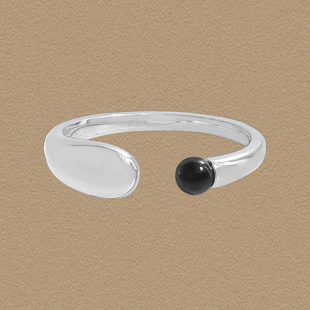 Polished sterling silver open ring with a crescent end and black bead on one side.