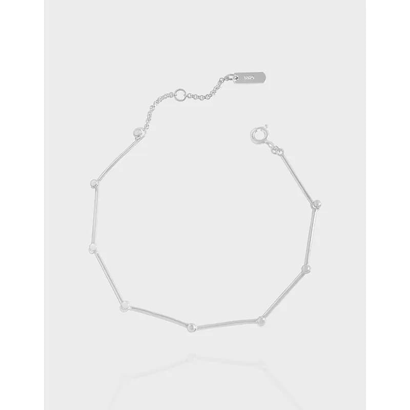 Polished sterling silver geometric bar chain bracelet with elongated segments laid flat on a white background.
