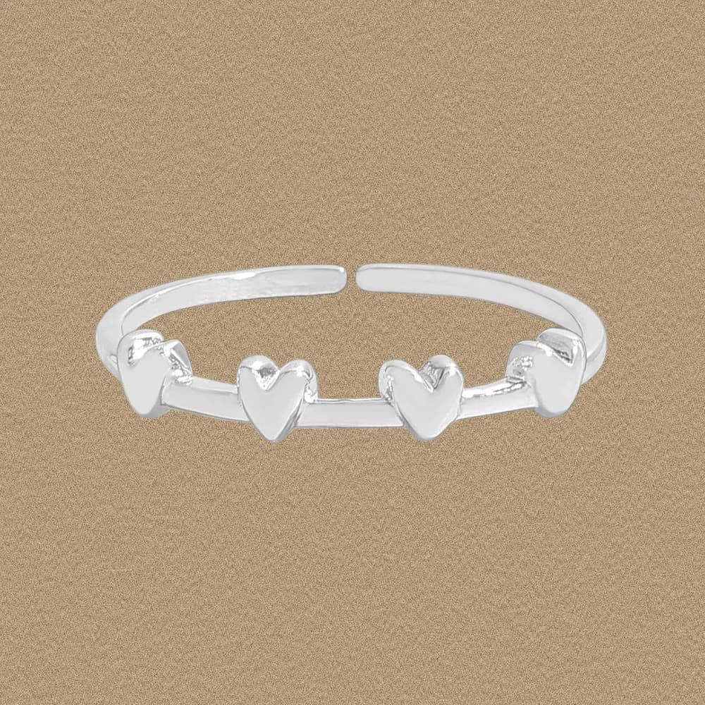 Open sterling silver ring with a row of small heart charms on a polished band.