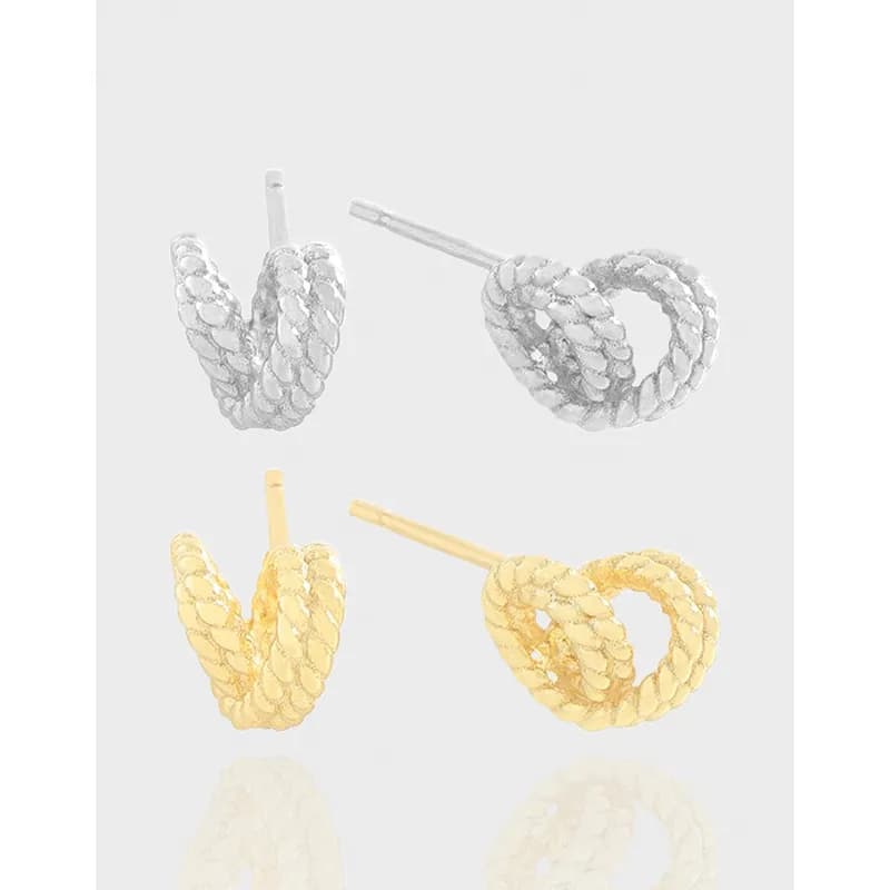 Polished rope-twist hoop earrings in silver and gold-tone finishes on display