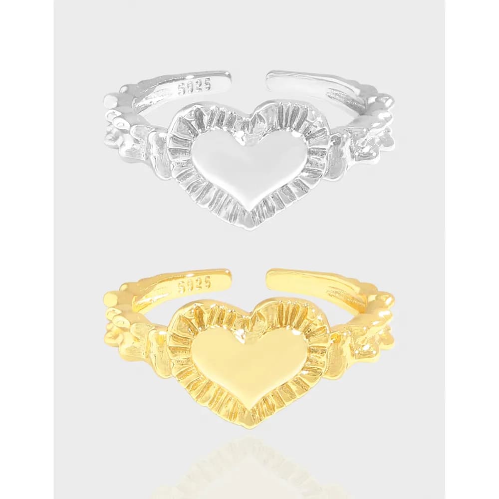 Front view of silver and gold-tone heart sunburst rings displayed together.