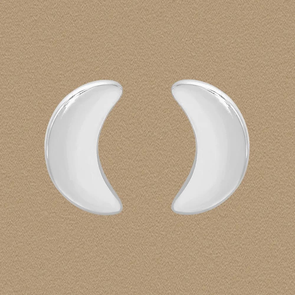 Polished sterling silver crescent earrings displayed on a neutral sandy background.