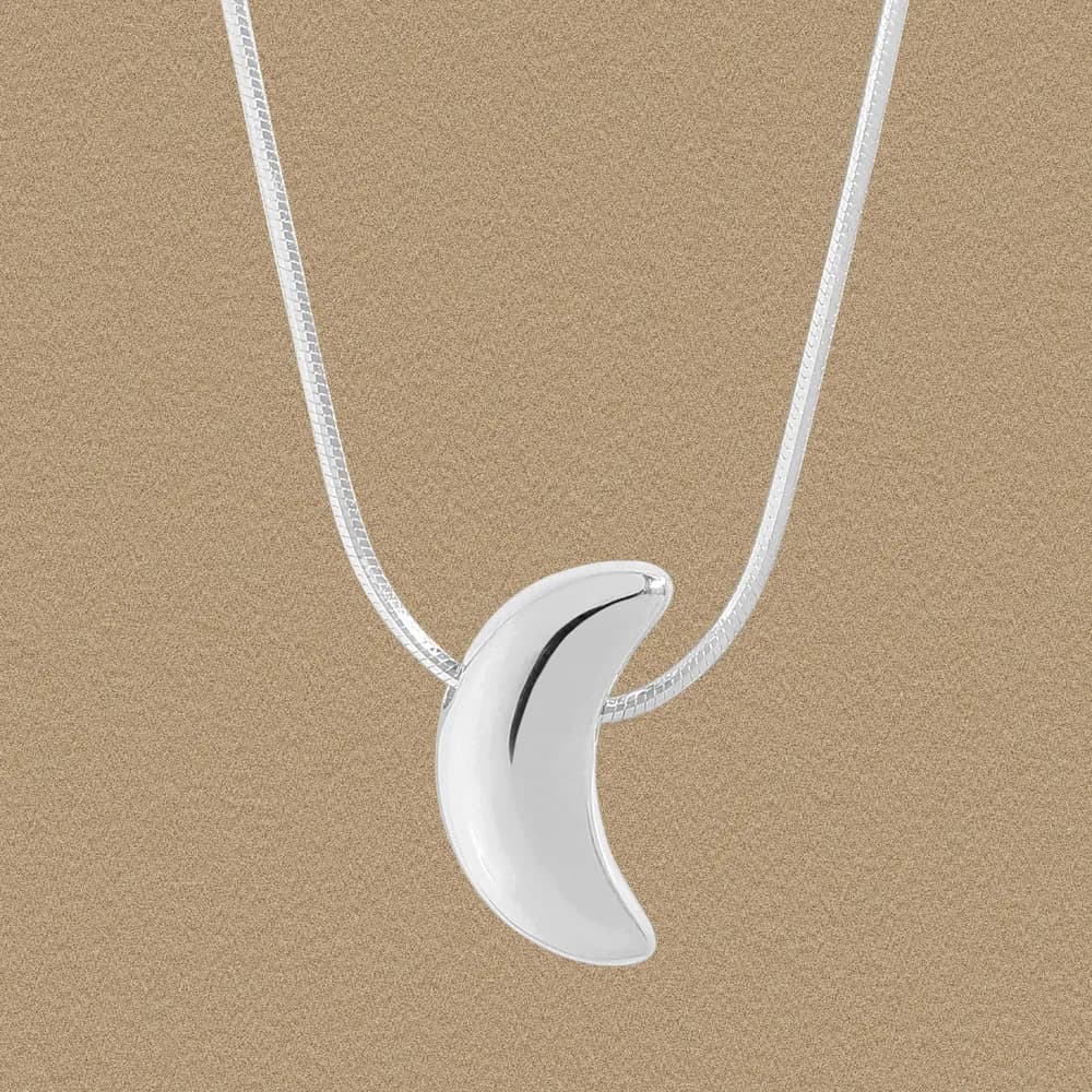 Polished silver crescent pendant on a slender snake chain
