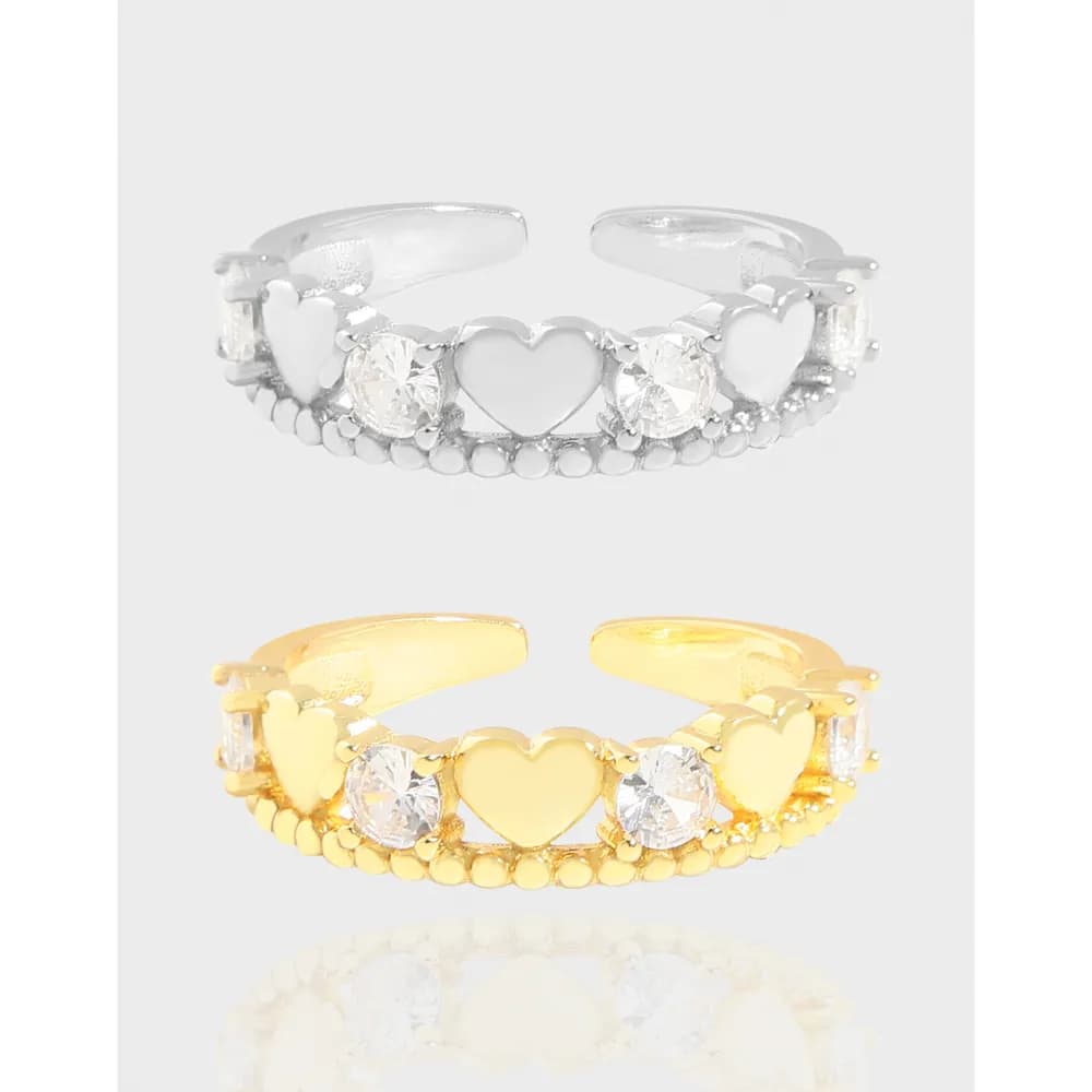 Open-ended silver ring featuring heart shapes and crystal stones on a beaded band.