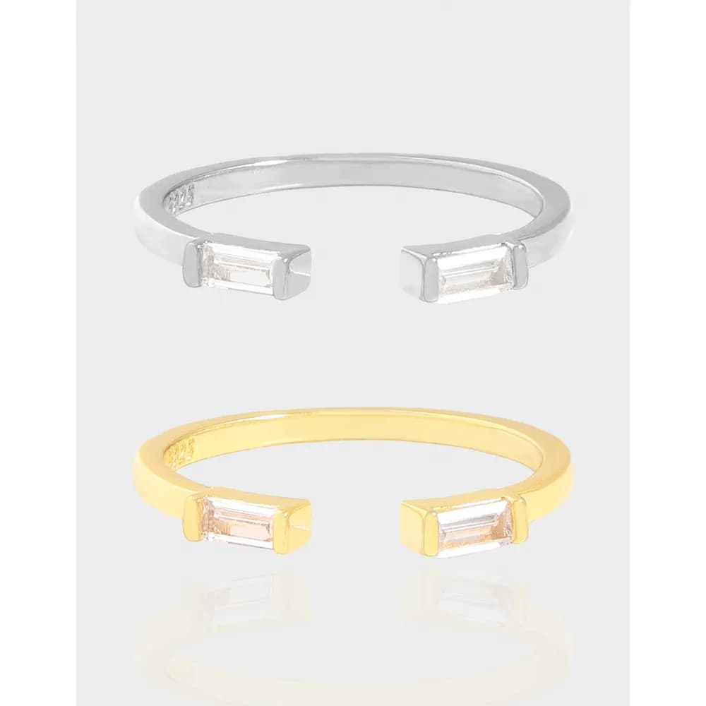 Open-ended ring with rectangular baguette stones at each end, shown in silver and gold-tone finishes.
