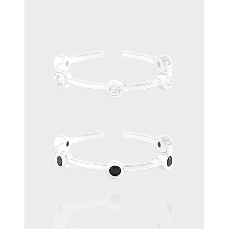 Open sterling silver ring with round bezel stones along the band