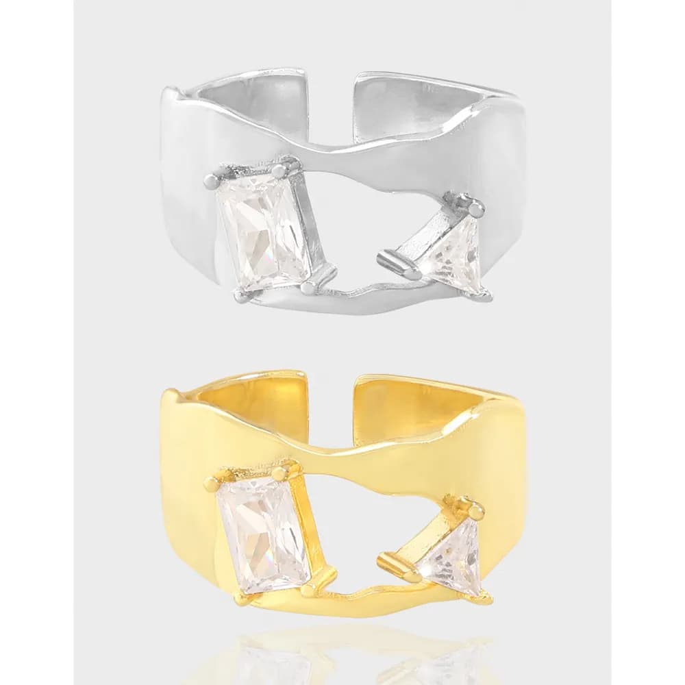 Silver and gold plated rings with a curved open band and two prong-set stones at opposite ends.